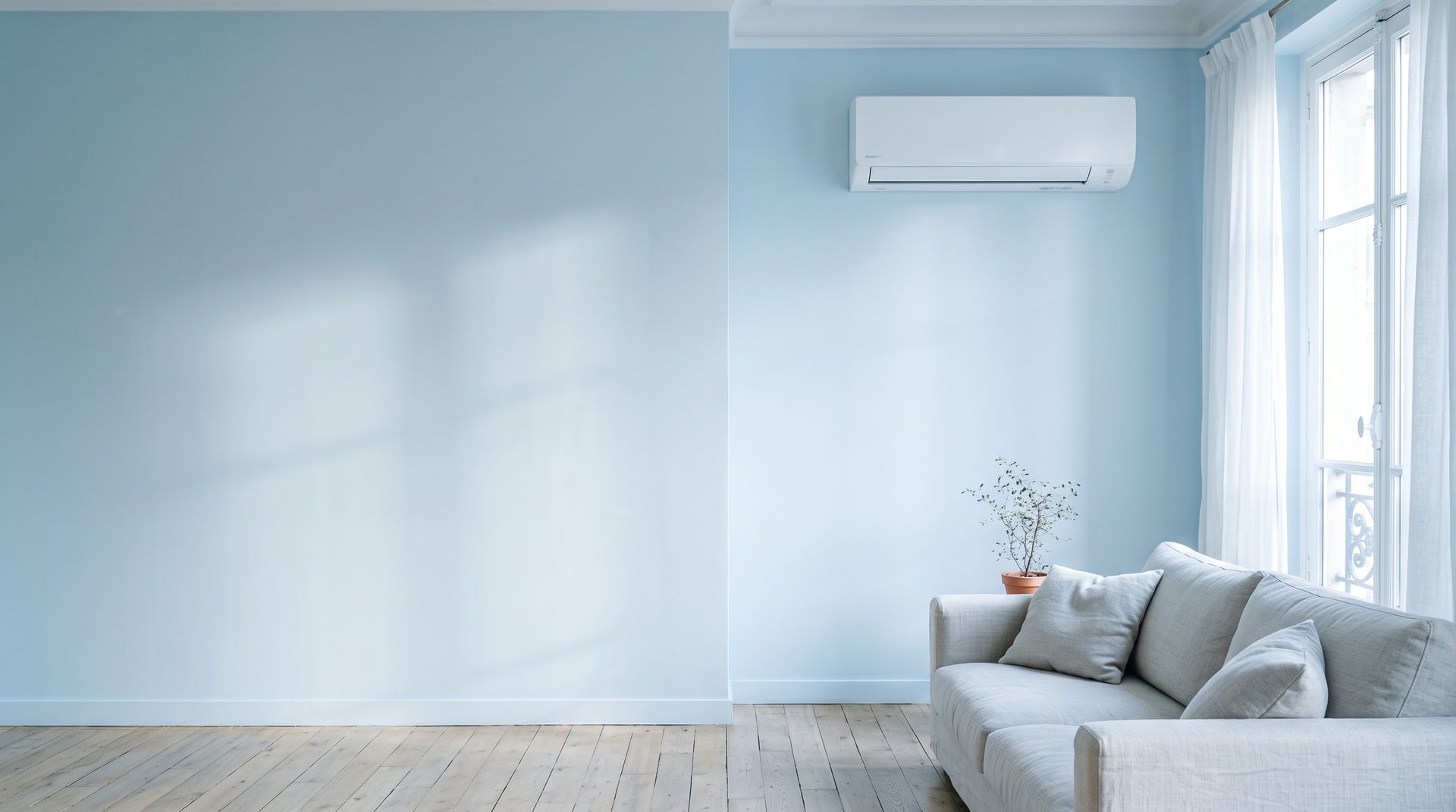 Salon clair avec une climatisation murale au-dessus du canapé